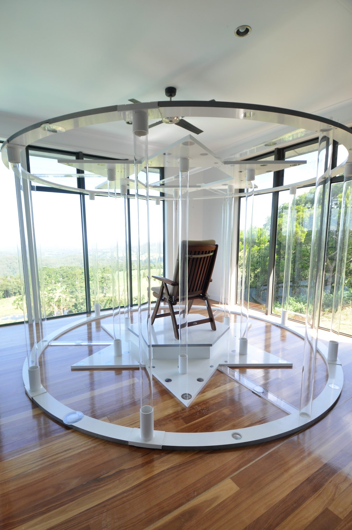The Teslas Starhenge, a ring of clear plates around a timber chair, with the hinterland beyond